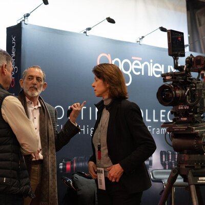 Un visiteur entre Christophe Remontet et Severine Serrano sur le stand Angénieux
 - Photo Lola Cacciarella

