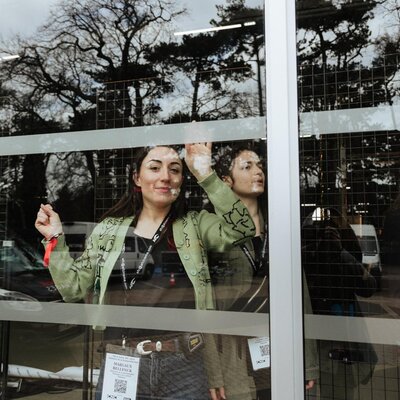 Margaux Bellynck, s’affairant derrière la baie vitrée sur le stand de Femmes à la caméra
 - Photo Katarzyna Średnicka

